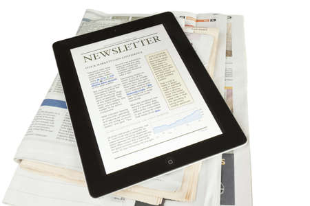 A ipad2 tablet on newspapers with a newsletter on a white background Stock Photo
