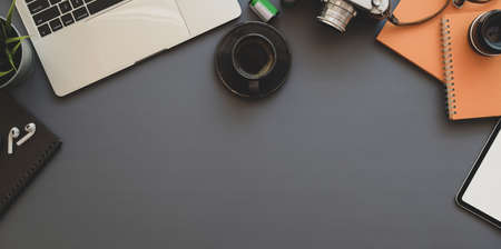 Modern photographer work station with copy space and office supplies on grey background desk