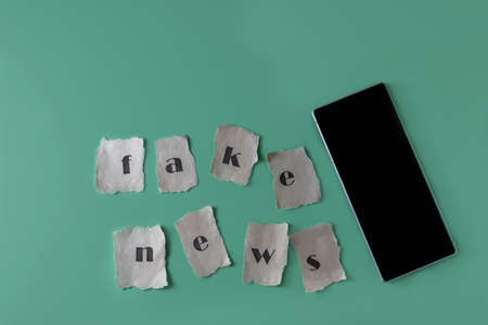 Fake news concept letters written on old paper on a green background social media concept copy space