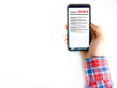 Smartphone on the screen the inscription today s news in a male hand and on the table Stock Photo