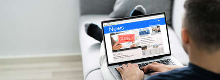 Man using computer reading electronic news articles