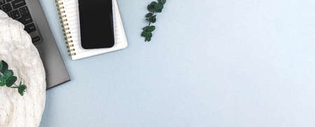 Flat lay business desktop concept blue background with laptop and smartphone copy space and top view photo