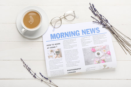Composition with newspaper and cup of coffee on light wooden background
