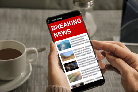 A woman reads a news site on a smartphone quick access to breaking news Stock Photo