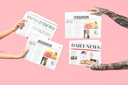 Female and male hands with newspapers on pink background Stock Photo