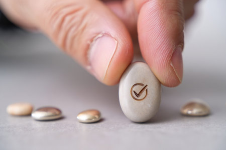 Placing smooth stone stone with check sign choice and approval Stock Photo