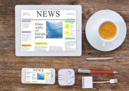 Top view office workplace set of tablet phone and cup of coffee on wooden background news site on screen