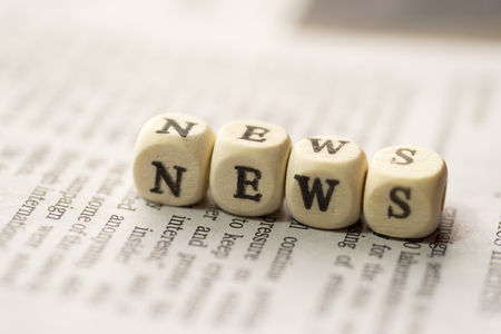 Wooden blocks with the text news on the newspaper Stock Photo