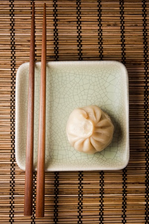Dumpling and chopstick on a bamboo mat